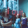 Three women in sequin dresses standing in front of a 'I Quit' sign.