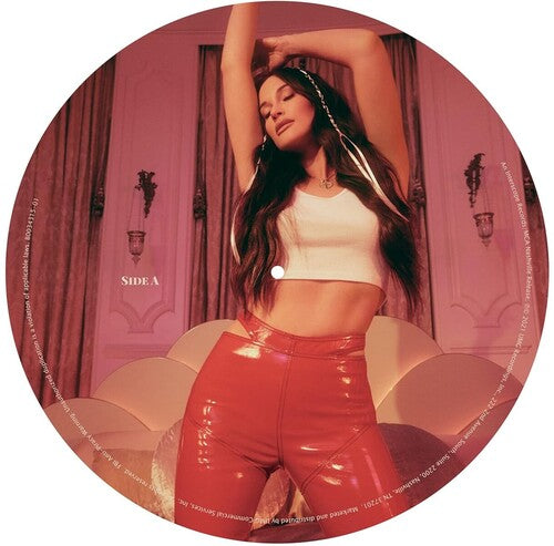 Vinyl record with a person in a white top and red pants against a pink curtain background