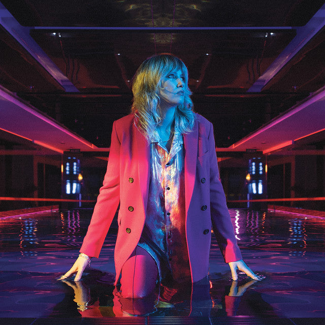 Person wearing a pink coat in a futuristic indoor setting with neon lights.