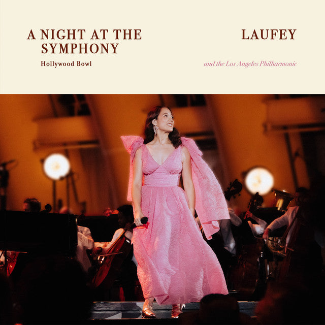 Woman in a pink dress on stage with 'A Night at the Symphony' and 'Laufey' text.