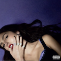 Cover art for Guts by Olivia Rodrigo featuring a photo of Olivia laying on a purple background with rings on her fingers spelling out the word 'Guts'.