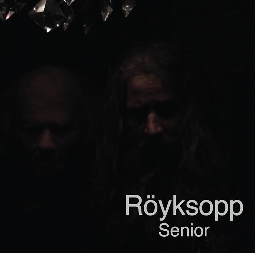 Album cover for Senior by Röyksopp featuring a minimalist black background with abstract white line artwork and understated typography, reflecting the album’s dark, cinematic electronic tone.