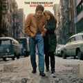 Album cover for The Freewheelin’ Bob Dylan by Bob Dylan featuring a black-and-white photograph of Bob Dylan and Suze Rotolo walking arm-in-arm down a snowy New York street, conveying a candid, early-1960s folk era mood.